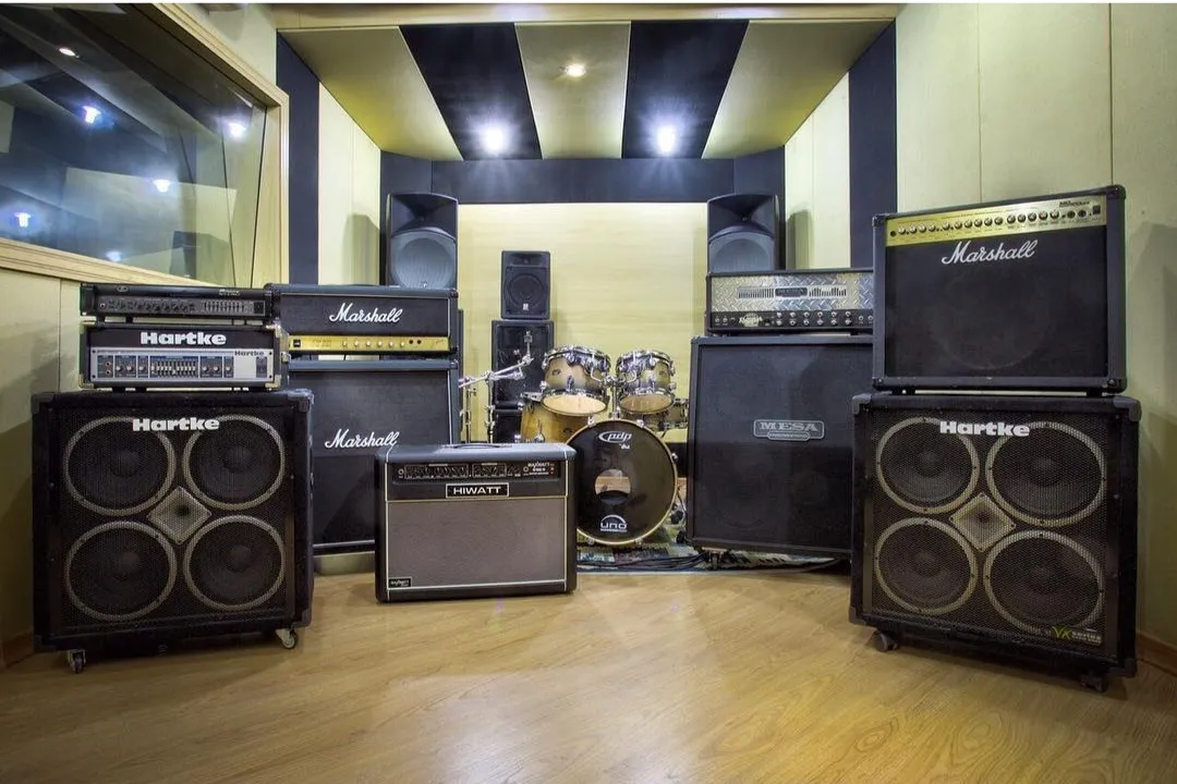 Parede de amplificadores Hartke e Marshall na sala de ensaio