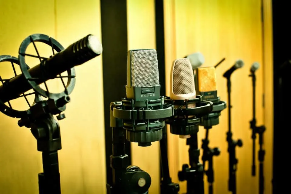 Microfones de estúdio iluminados em cabine acústica